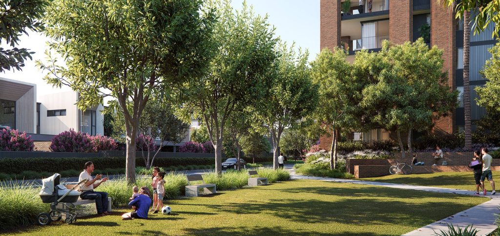 Community park with lush trees, benches, and children playing soccer, with modern residential buildings in the background.