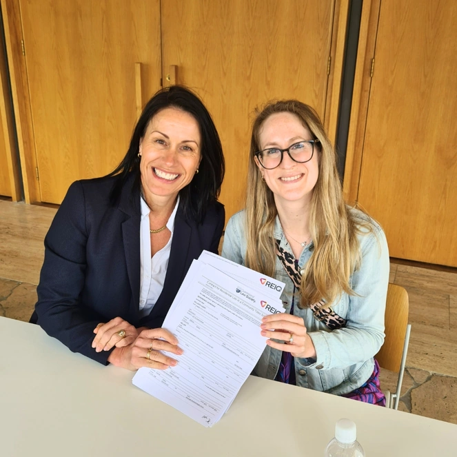 Brisbane buyer’s agent with client holding a property contract.